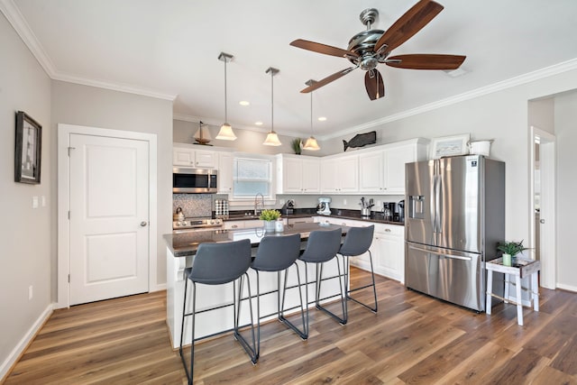 kitchen featuring white cabinetry, stainless steel appliances, a center island, and dark hardwood / wood-style floors