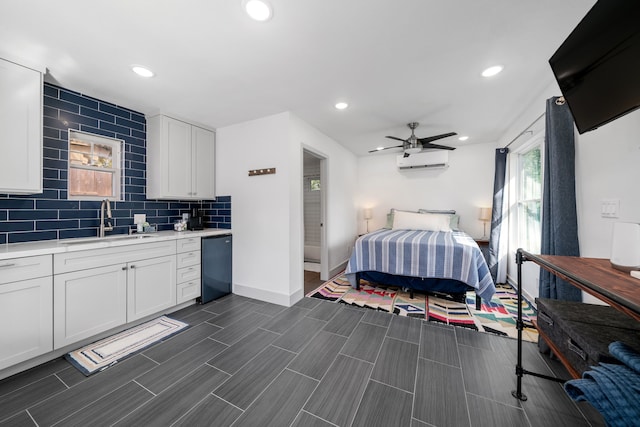 bedroom featuring ceiling fan, an AC wall unit, and sink