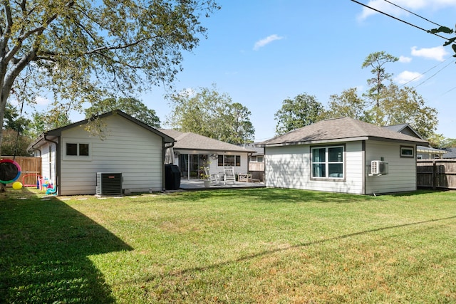 rear view of property with a yard and cooling unit