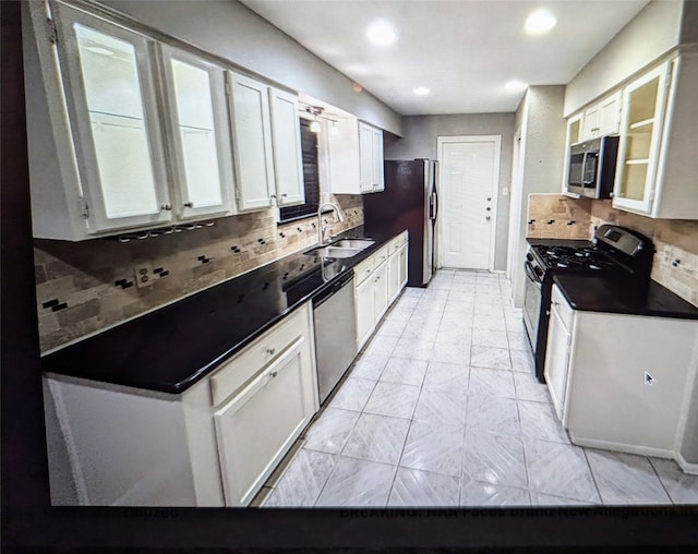 kitchen with appliances with stainless steel finishes, decorative backsplash, white cabinets, and sink