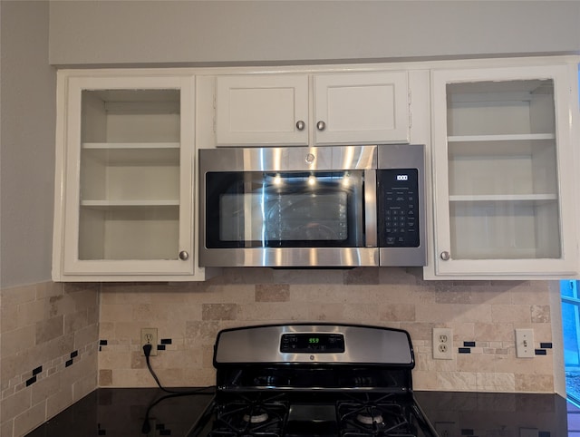 kitchen with white cabinets, tasteful backsplash, and stainless steel appliances