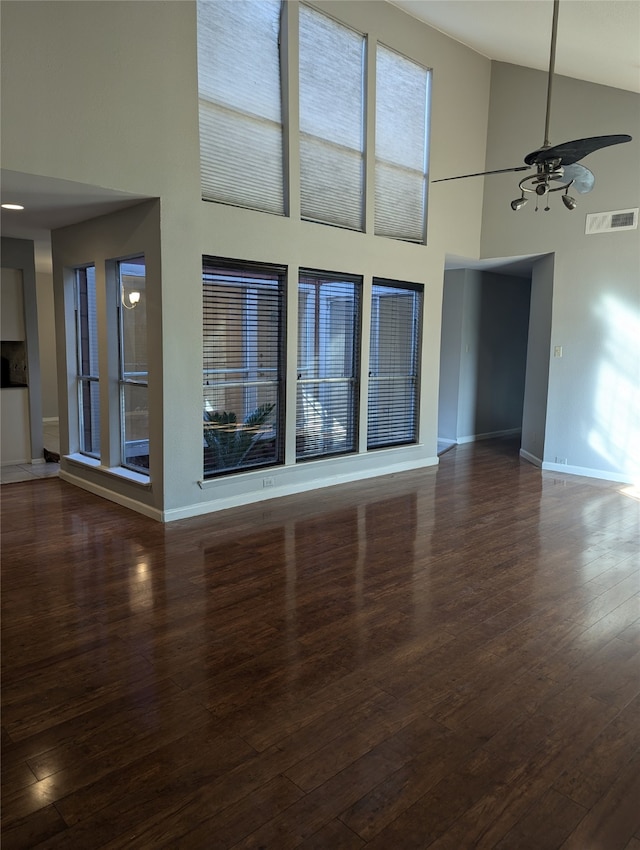 unfurnished living room with ceiling fan, high vaulted ceiling, and dark hardwood / wood-style floors