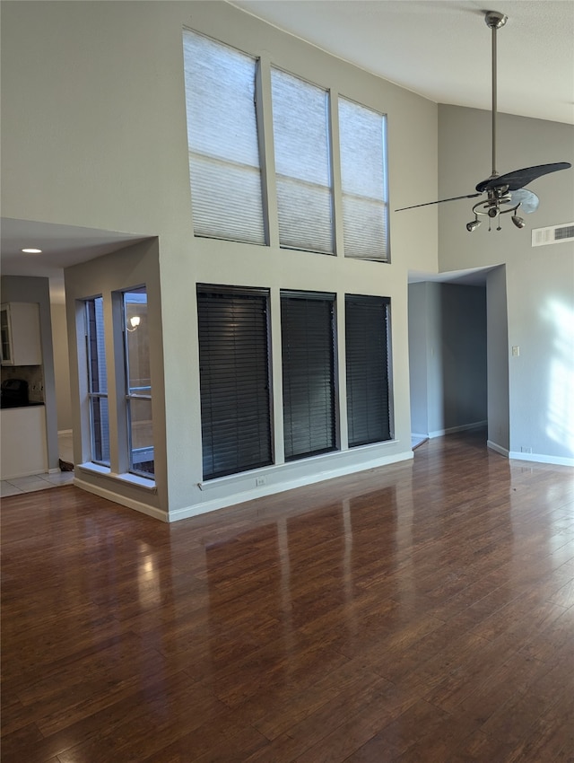 unfurnished living room with an inviting chandelier, dark hardwood / wood-style floors, and high vaulted ceiling