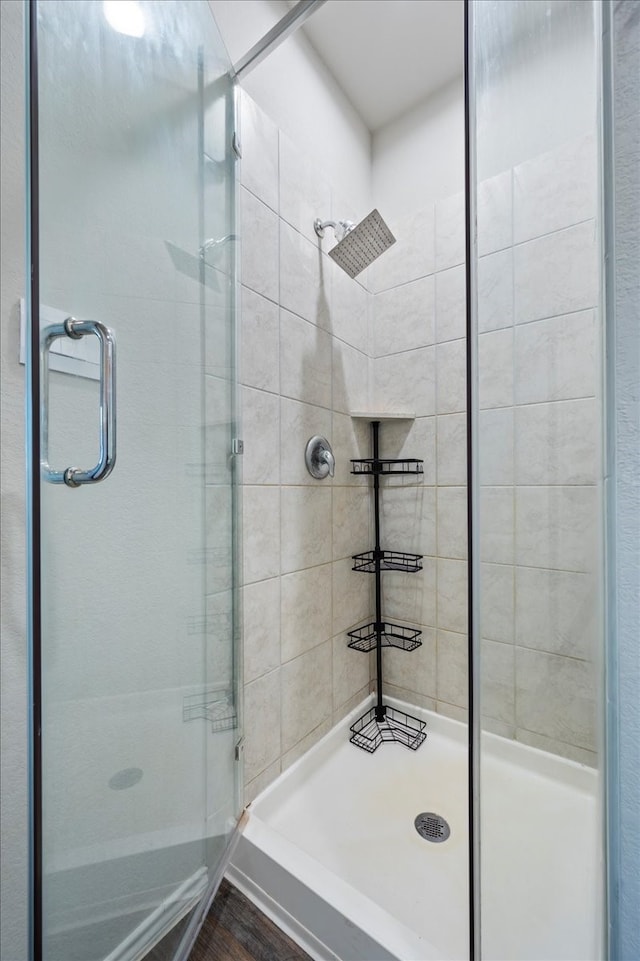 bathroom featuring hardwood / wood-style floors and a shower with shower door