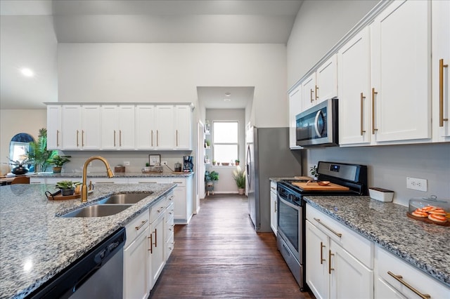 kitchen with appliances with stainless steel finishes, dark hardwood / wood-style floors, light stone countertops, sink, and white cabinets