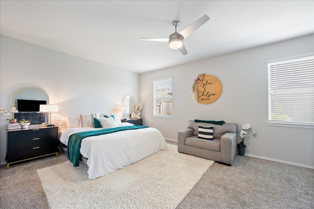 carpeted bedroom featuring multiple windows and ceiling fan