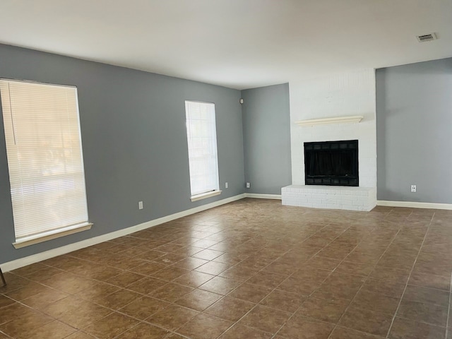 unfurnished living room with a brick fireplace