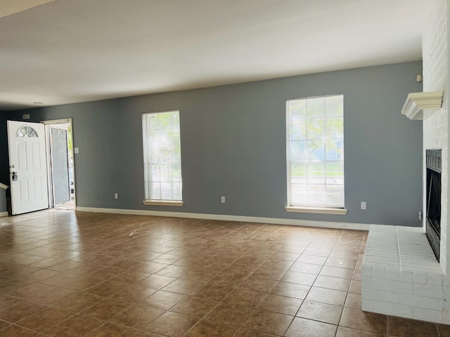 unfurnished living room with a fireplace and tile patterned flooring