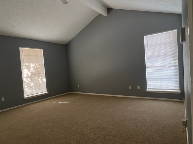 carpeted empty room featuring lofted ceiling with beams and a textured ceiling