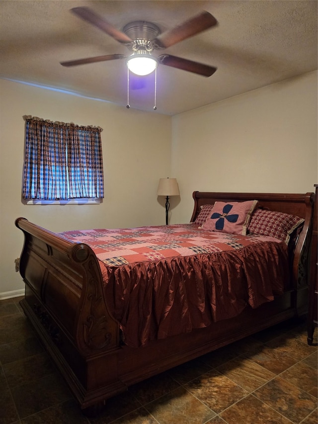 bedroom with ceiling fan and a textured ceiling