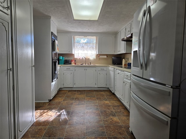 kitchen featuring dishwasher, sink, a textured ceiling, white cabinets, and stainless steel refrigerator with ice dispenser