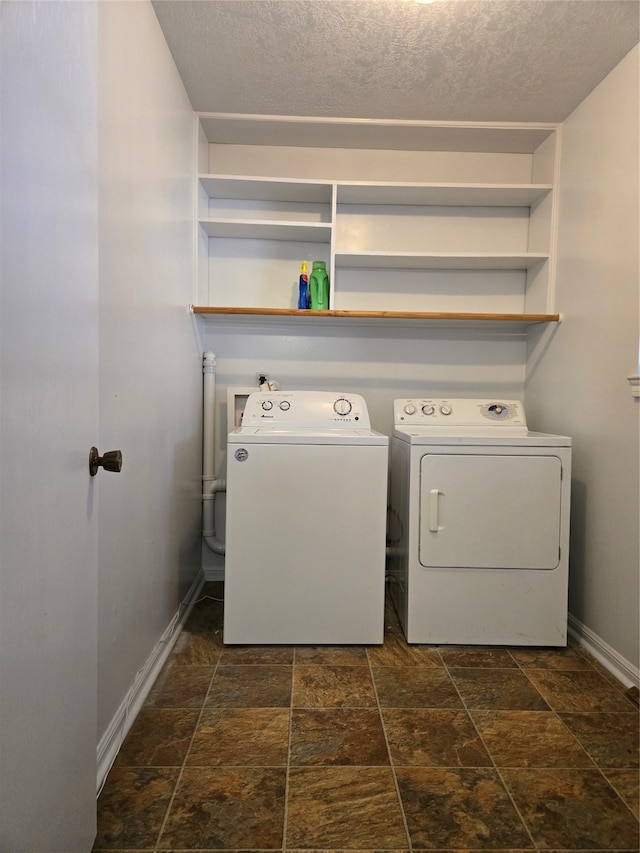 laundry area featuring washer and clothes dryer and a textured ceiling