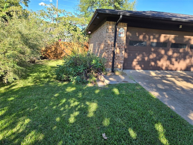 view of side of home with a garage and a lawn