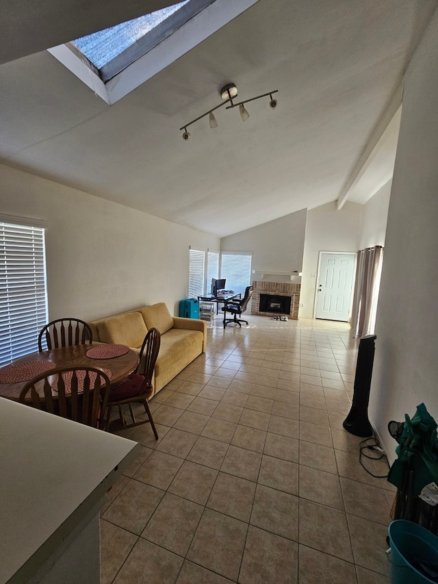 unfurnished living room with tile patterned floors, vaulted ceiling with skylight, and a brick fireplace