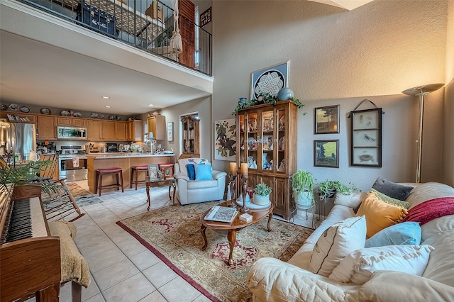 tiled living room featuring a high ceiling