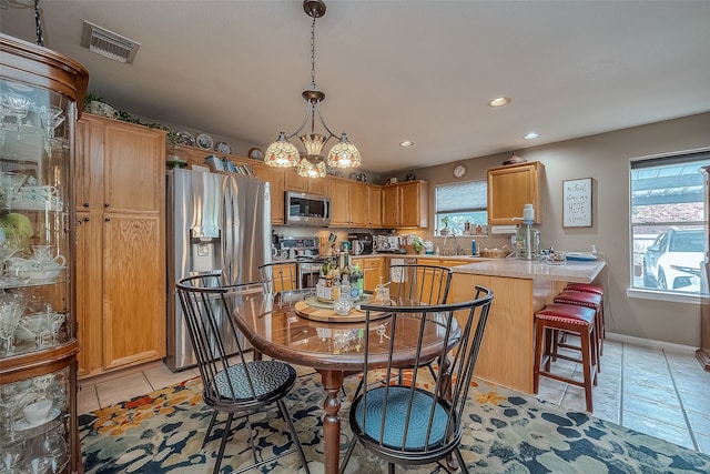 dining space featuring a wealth of natural light, sink, and a notable chandelier