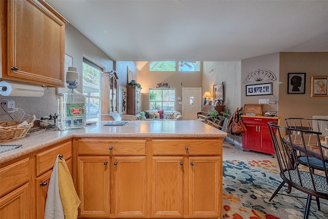 kitchen featuring a skylight, kitchen peninsula, and light tile patterned floors