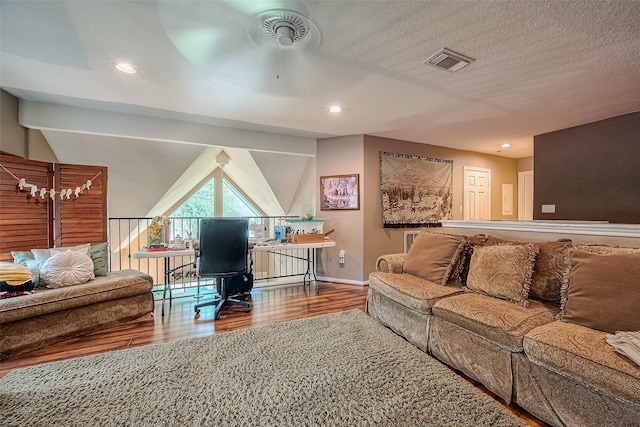 living room with hardwood / wood-style floors, a textured ceiling, and ceiling fan