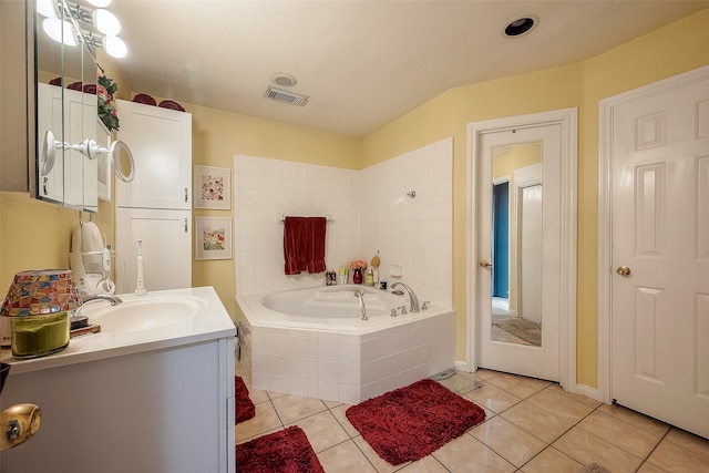 bathroom with vanity, tiled tub, and tile patterned floors