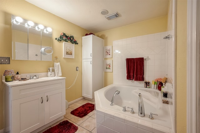 bathroom featuring vanity, tile patterned floors, and tiled bath