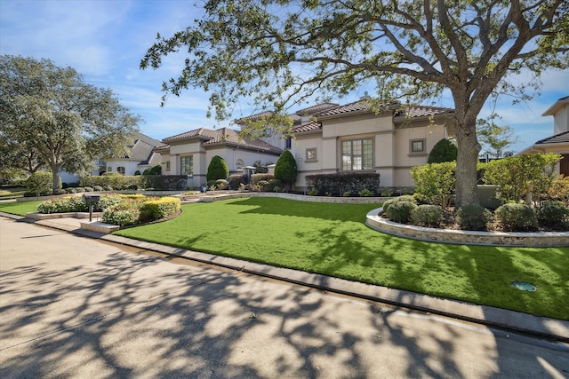 mediterranean / spanish house featuring a front lawn