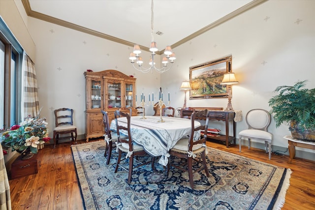 dining area featuring ornamental molding, dark wood-type flooring, and a notable chandelier