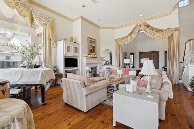 living room featuring dark hardwood / wood-style floors, a healthy amount of sunlight, and ornamental molding