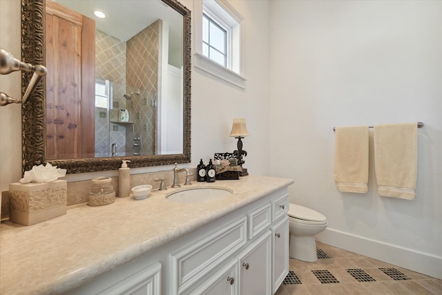 bathroom featuring tile patterned floors, vanity, toilet, and a shower with shower door