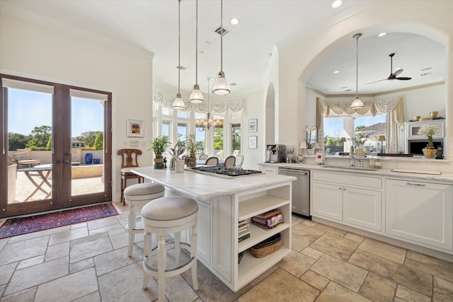 kitchen featuring french doors, stainless steel appliances, sink, decorative light fixtures, and white cabinetry