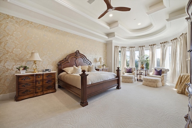 bedroom featuring ceiling fan, light colored carpet, crown molding, and a tray ceiling