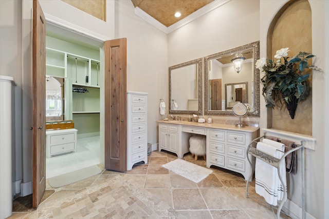 bathroom featuring vanity, ornamental molding, and a high ceiling