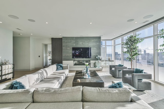 living room featuring a healthy amount of sunlight and floor to ceiling windows