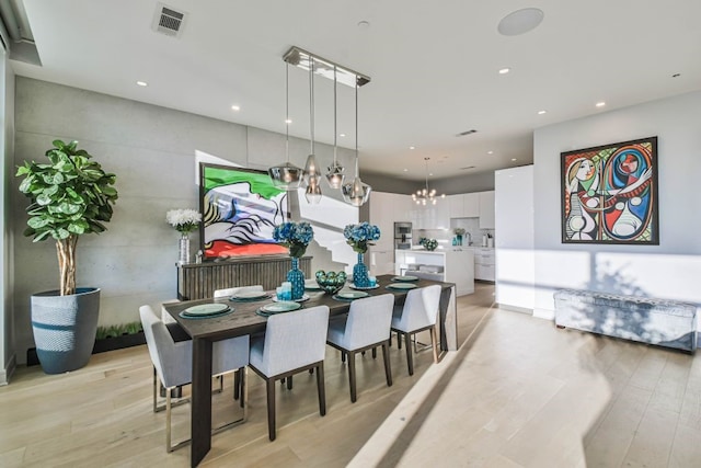 dining room featuring light hardwood / wood-style flooring and an inviting chandelier