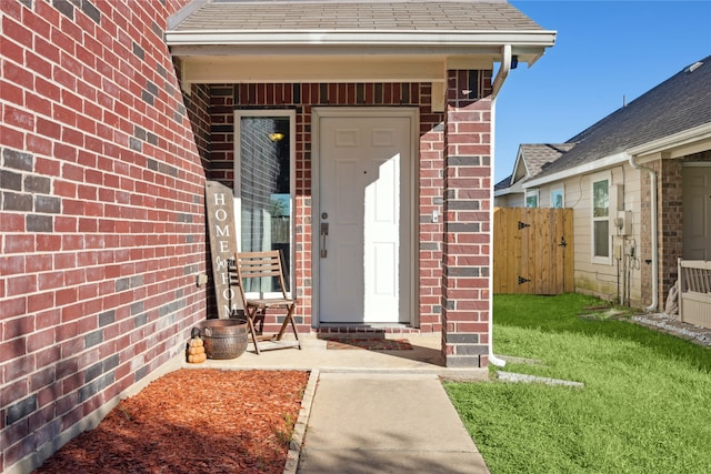 view of exterior entry featuring a yard