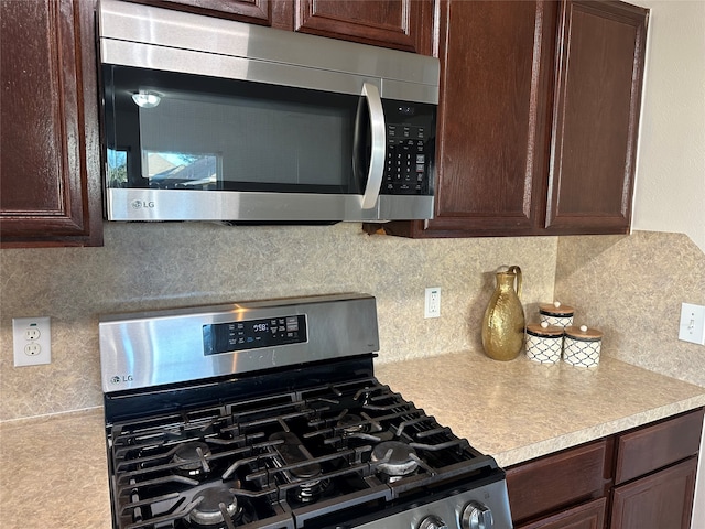 kitchen featuring appliances with stainless steel finishes, backsplash, and dark brown cabinets