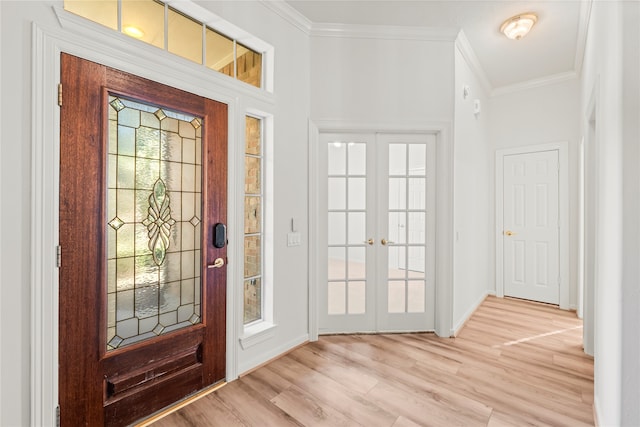 foyer featuring crown molding, french doors, and light wood-type flooring