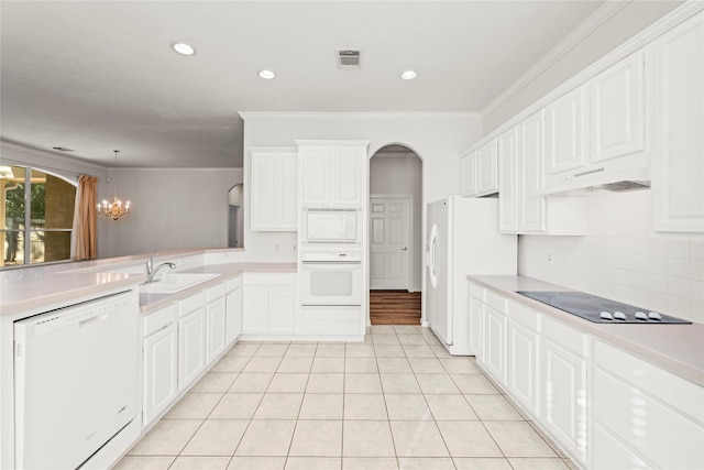 23 Wilmington Way, Conroe, TX 77384 - kitchen with white appliances, ornamental molding, a sink, decorative backsplash, and arched walkways