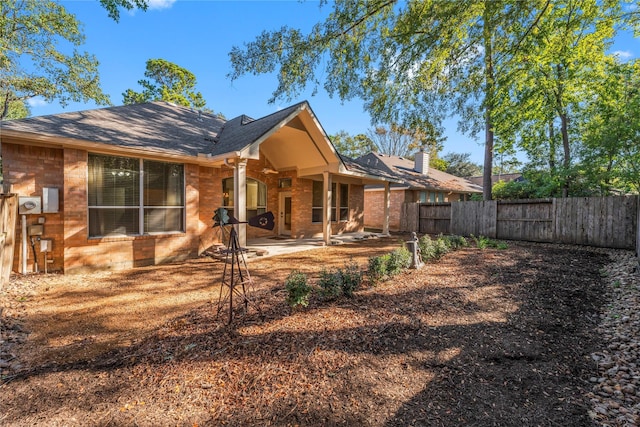 23 Wilmington Way, Conroe, TX 77384 - back of property with a patio area, brick siding, roof with shingles, and a chimney