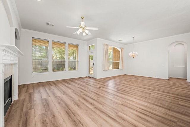 23 Wilmington Way, Conroe, TX 77384 - unfurnished living room with a fireplace, ornamental molding, a ceiling fan, light wood-type flooring, and a chandelier