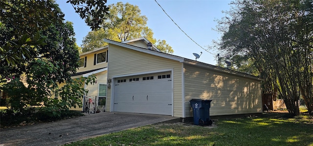 view of side of home featuring a garage and a yard