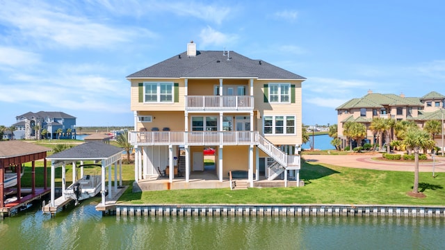 rear view of house featuring a yard and a water view