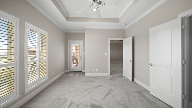 unfurnished bedroom featuring crown molding, multiple windows, light colored carpet, and ceiling fan