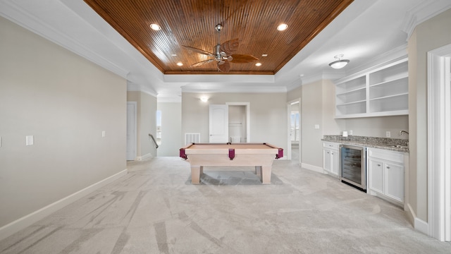 recreation room featuring beverage cooler, a raised ceiling, wooden ceiling, wet bar, and light colored carpet