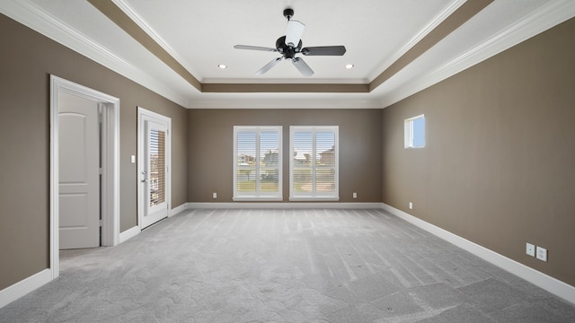 unfurnished room with light carpet, crown molding, a tray ceiling, and ceiling fan