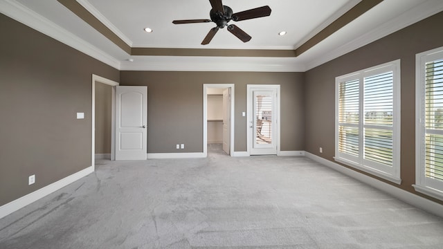 unfurnished bedroom featuring light carpet, ceiling fan, a spacious closet, ornamental molding, and a closet