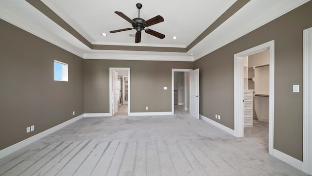 unfurnished bedroom featuring a spacious closet, ceiling fan, a closet, and crown molding