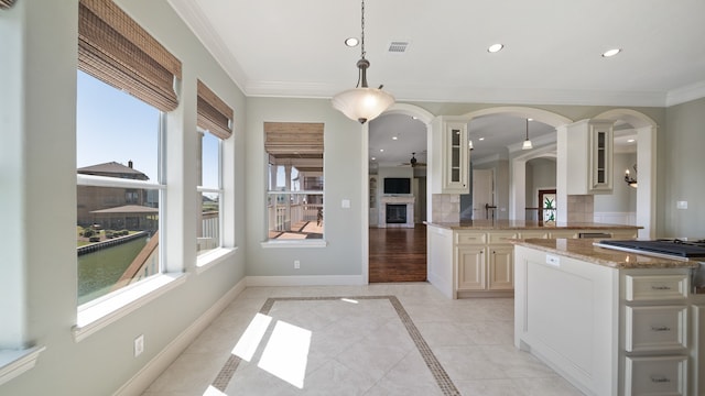 kitchen featuring light tile patterned flooring, kitchen peninsula, hanging light fixtures, crown molding, and decorative backsplash