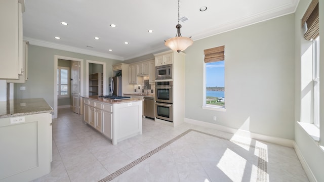 kitchen with hanging light fixtures, stainless steel appliances, crown molding, a center island, and a water view