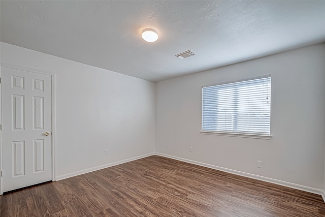 unfurnished room featuring hardwood / wood-style floors and a textured ceiling