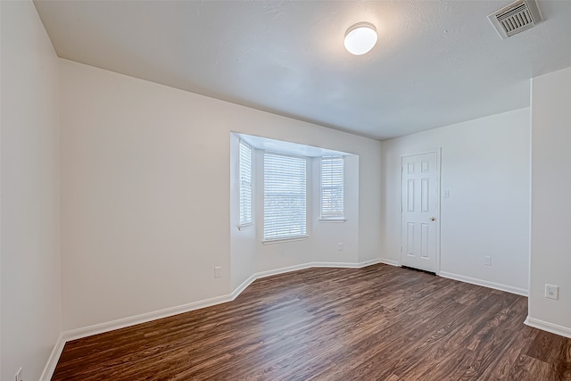 spare room with dark hardwood / wood-style flooring